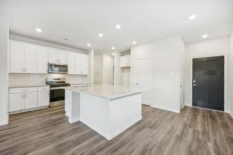 519 Ridgedale Drive McKinney, TX 75071 - Photo 6 of 26 a kitchen with white cabinets and stainless steel appliances