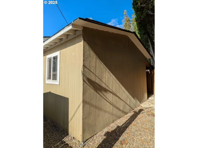 a view of a pathway of a house with wooden fence