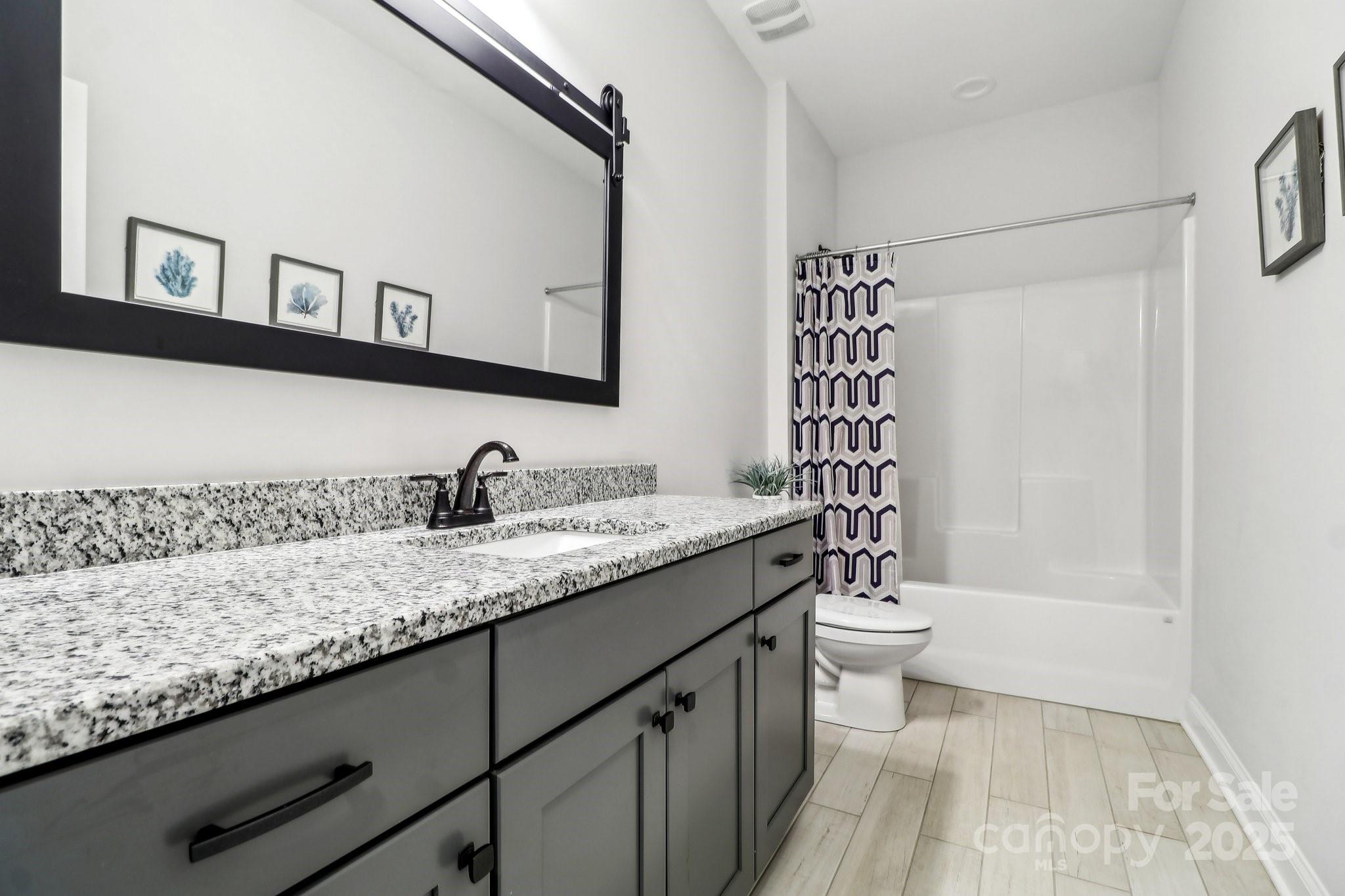 754 Culp Fergusen Drive Lancaster, SC 29720 - Photo 29 of 35 a bathroom with a granite countertop sink a toilet a mirror a vanity and shower