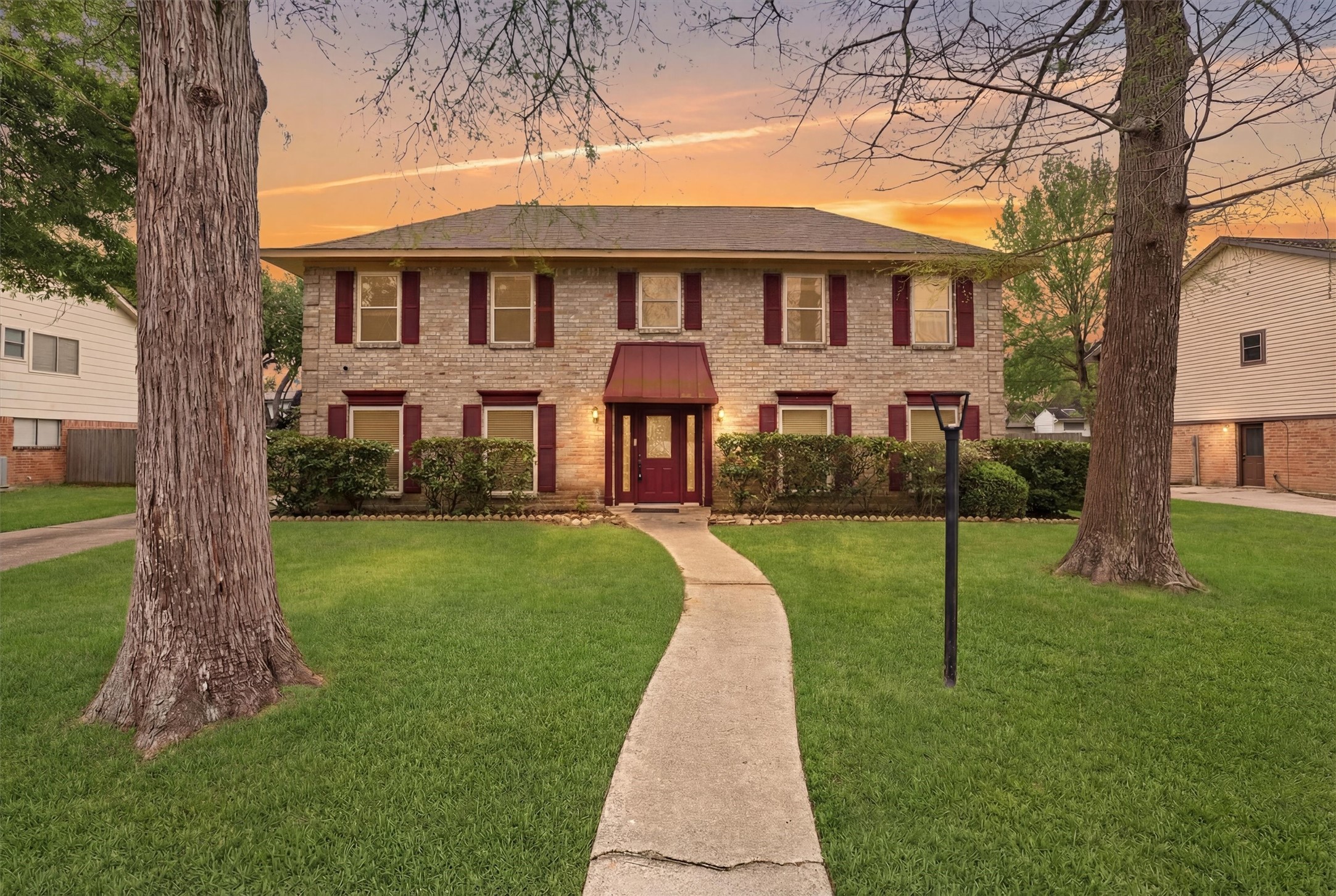 8115 Theisswood Road Spring, TX 77379 - Photo 2 of 41 A gorgeous twilight view highlighting the home's striking curb appeal, covered entryway, and classic architecture
