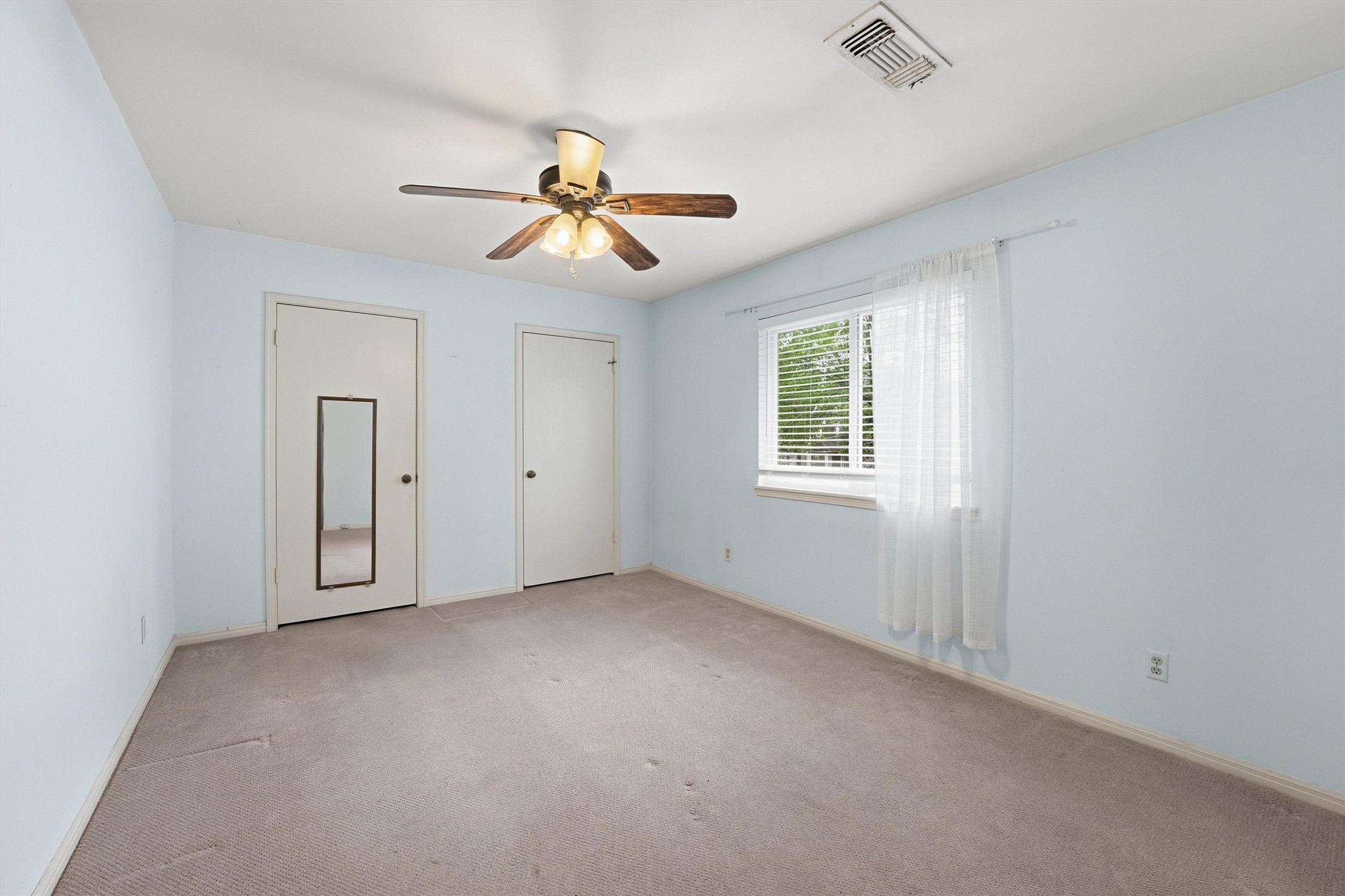 8115 Theisswood Road Spring, TX 77379 - Photo 22 of 41 Clean and bright secondary bedroom with a ceiling fan