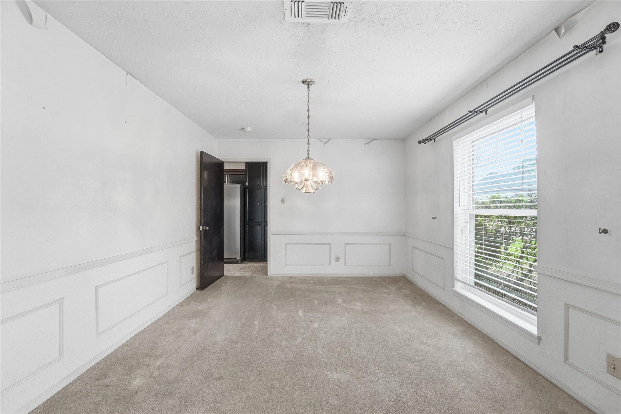 8115 Theisswood Road Spring, TX 77379 - Photo 8 of 41 classic wainscoting details, an elegant chandelier, and large windows that let in abundant natural light