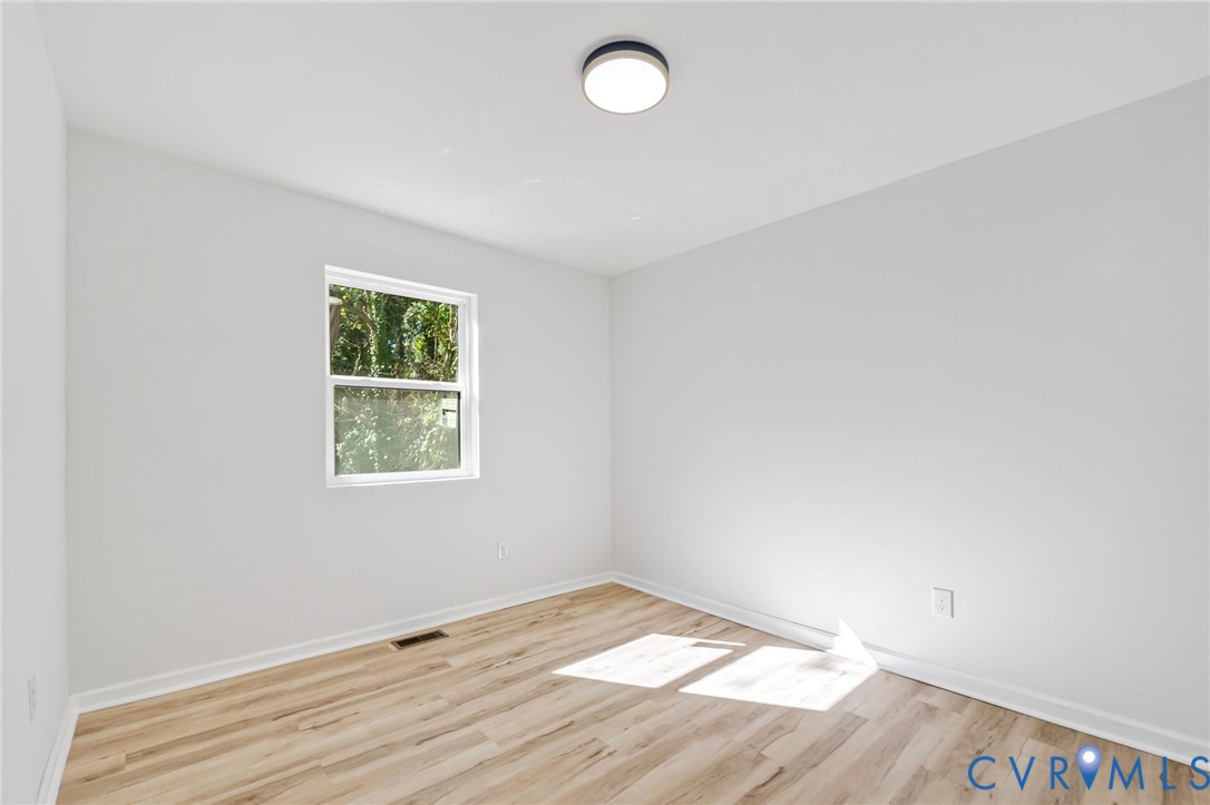 21514 Pannill Street Petersburg, VA 23803 - Photo 12 of 21 an empty room with wooden floor and windows