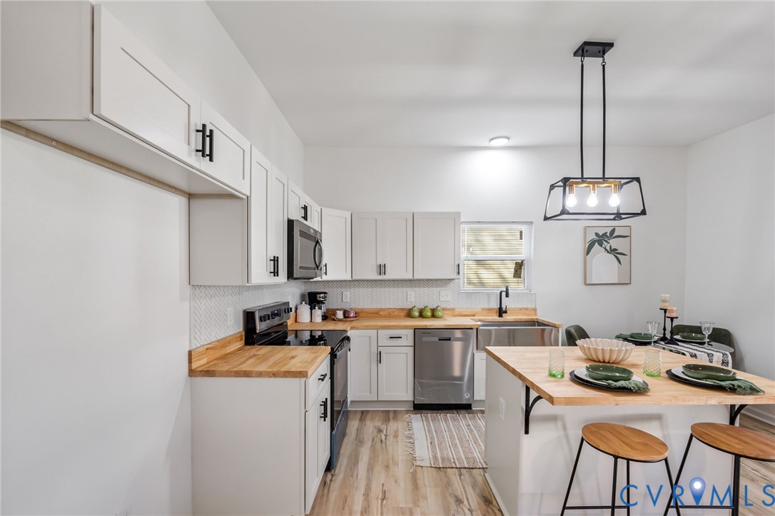 21514 Pannill Street Petersburg, VA 23803 - Photo 6 of 21 a kitchen with a sink a stove and chairs
