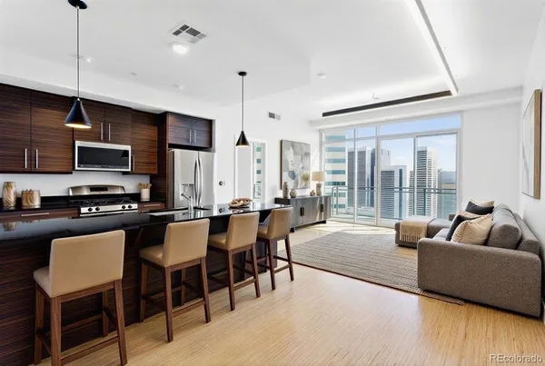 a living room with furniture a flat screen tv and kitchen view