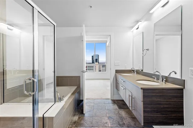 a spacious bathroom with a double vanity sink a mirror and a bathtub