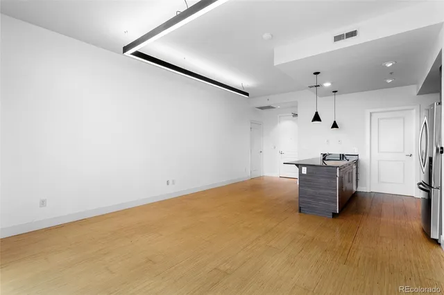 a room with kitchen island stainless steel appliances sink and cabinets