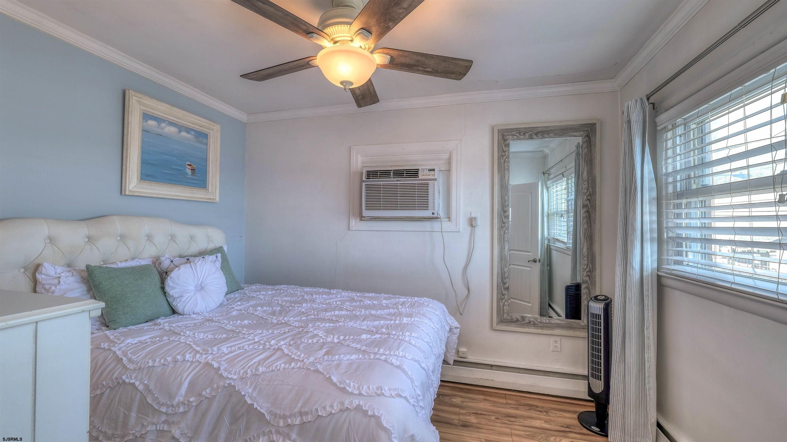 9500 Amherst Avenue, Unit 10 AKA 9 Margate City, NJ 08402 - Photo 11 of 20 a bedroom with a large bed and a chandelier