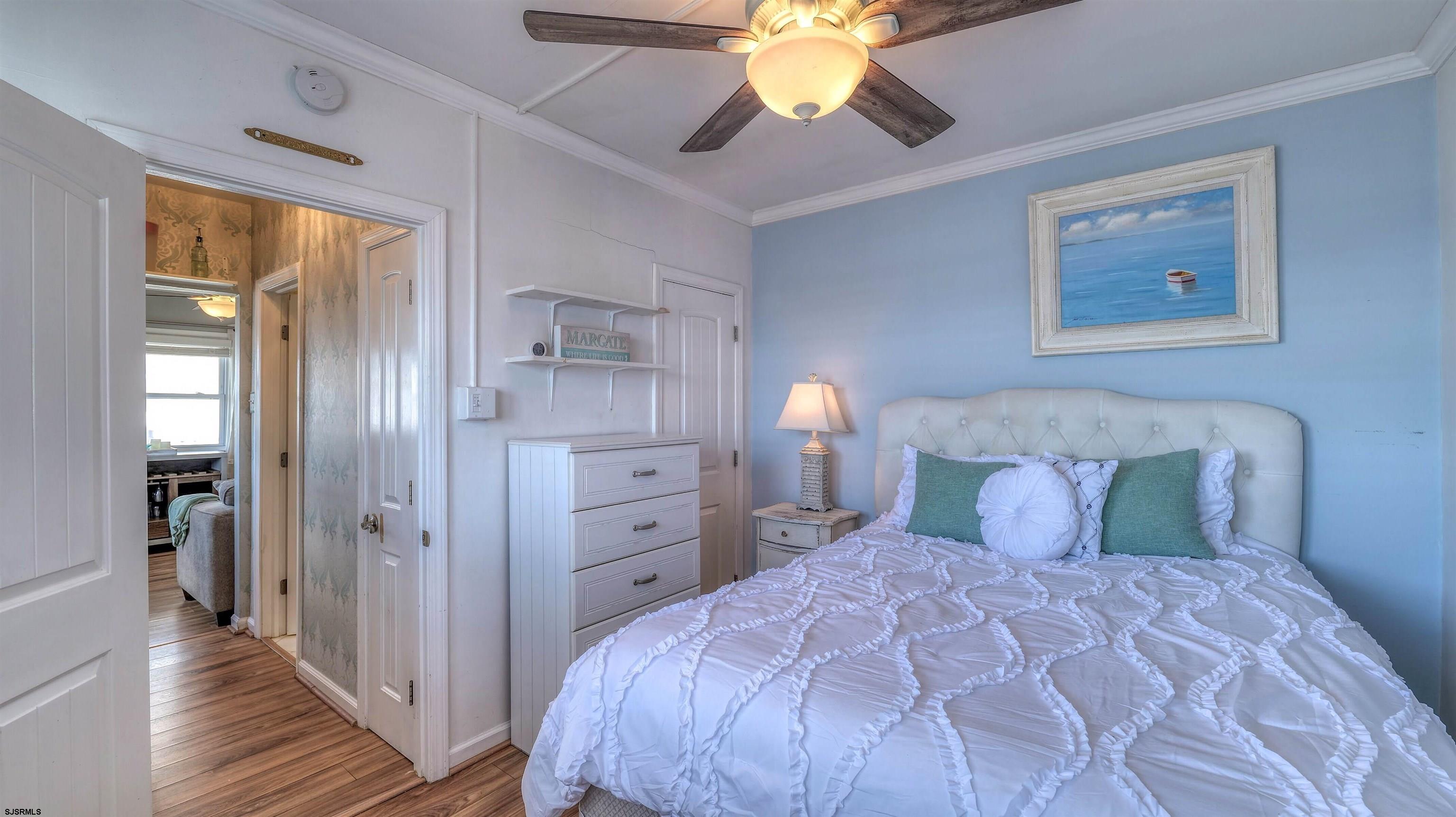9500 Amherst Avenue, Unit 10 AKA 9 Margate City, NJ 08402 - Photo 12 of 20 a bedroom with a bed and a chandelier