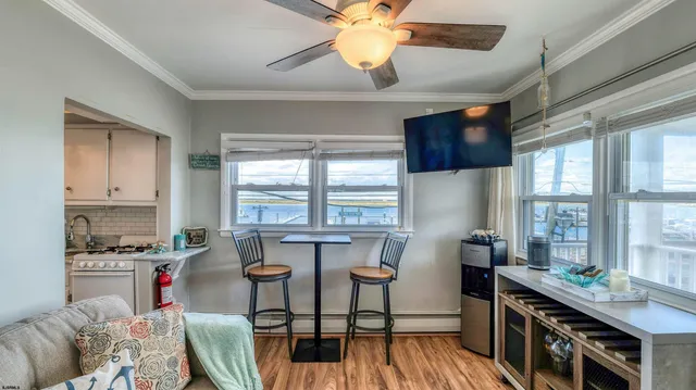 a kitchen with stainless steel appliances kitchen island granite countertop a table chairs in it and wooden floors