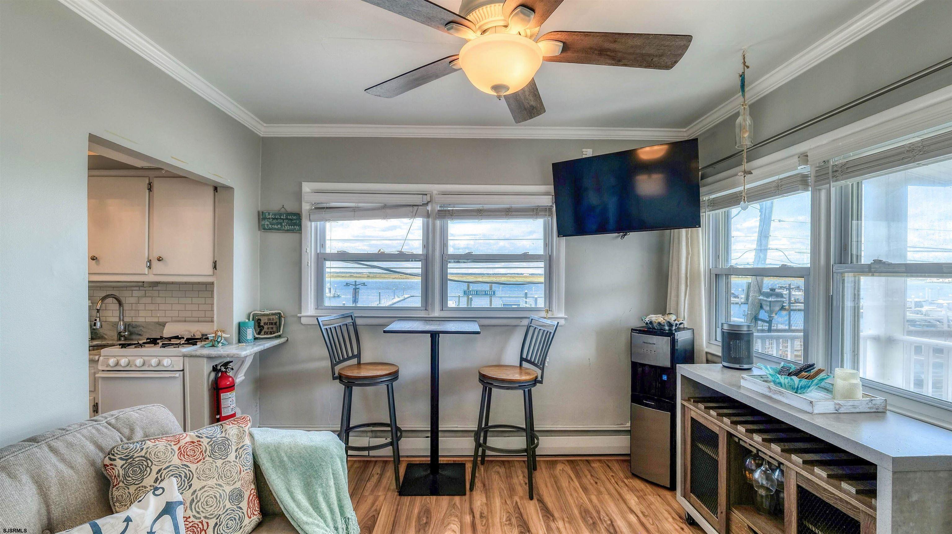 9500 Amherst Avenue, Unit 10 AKA 9 Margate City, NJ 08402 - Photo 4 of 20 a kitchen with stainless steel appliances kitchen island granite countertop a table chairs in it and wooden floors