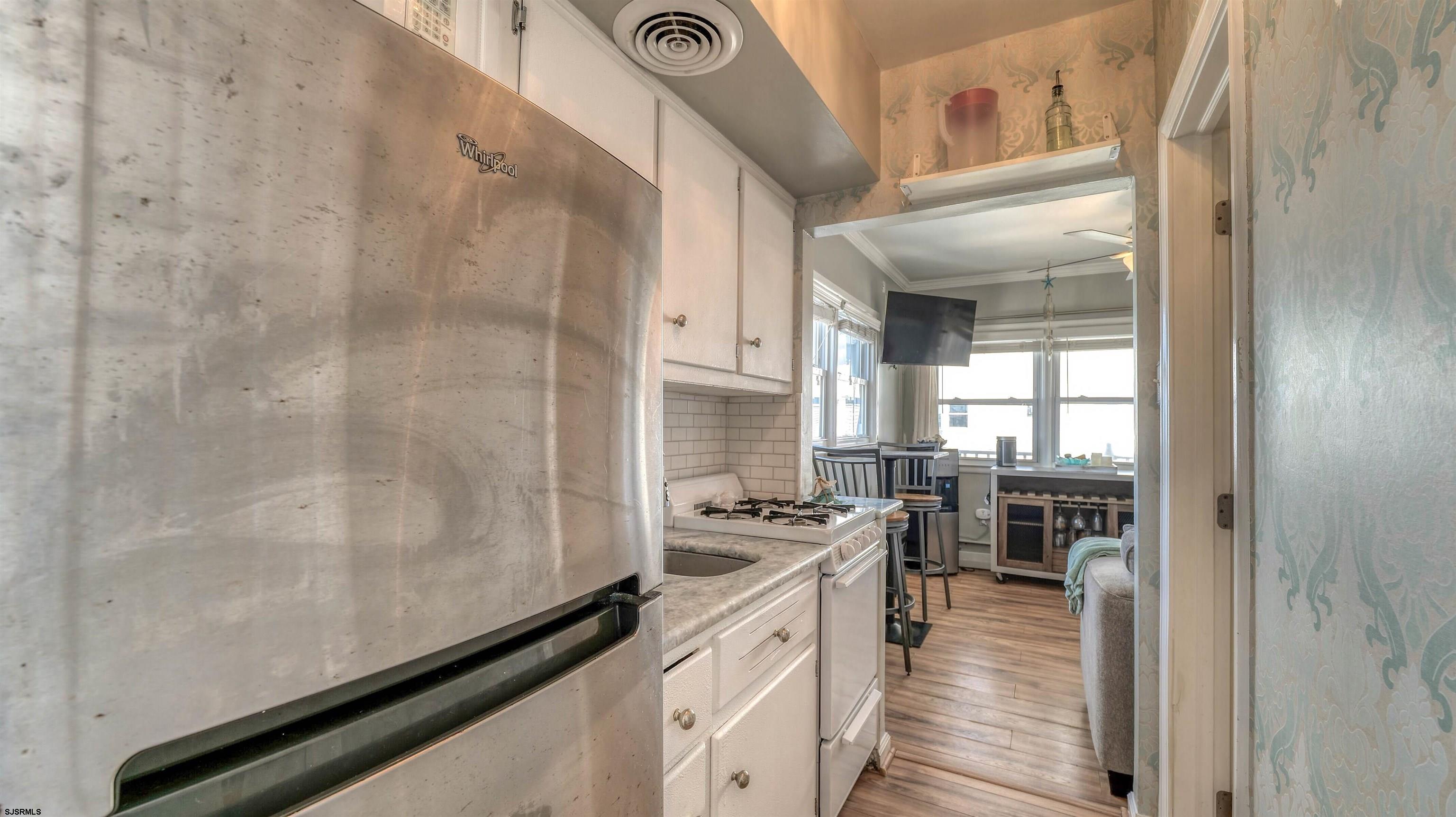 9500 Amherst Avenue, Unit 10 AKA 9 Margate City, NJ 08402 - Photo 7 of 20 a kitchen with stainless steel appliances a refrigerator a stove and white cabinets