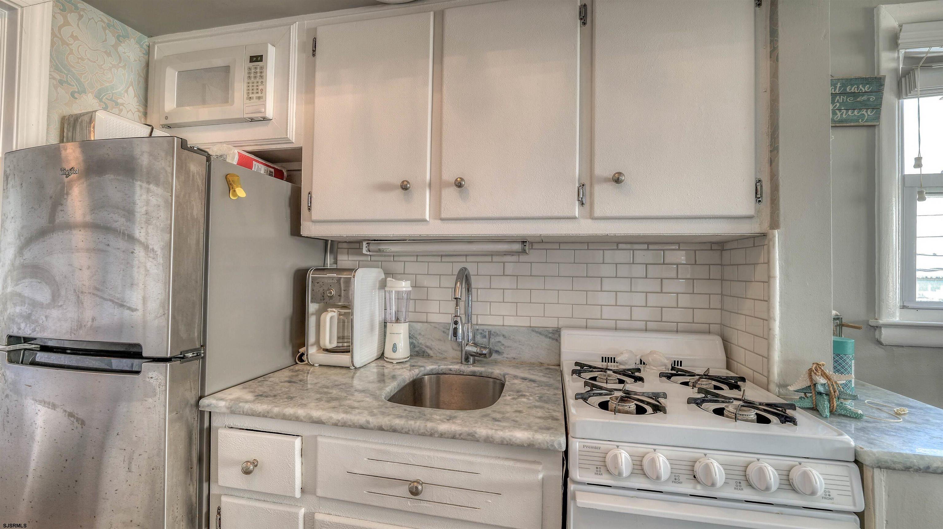 9500 Amherst Avenue, Unit 10 AKA 9 Margate City, NJ 08402 - Photo 9 of 20 a kitchen with a refrigerator and cabinets