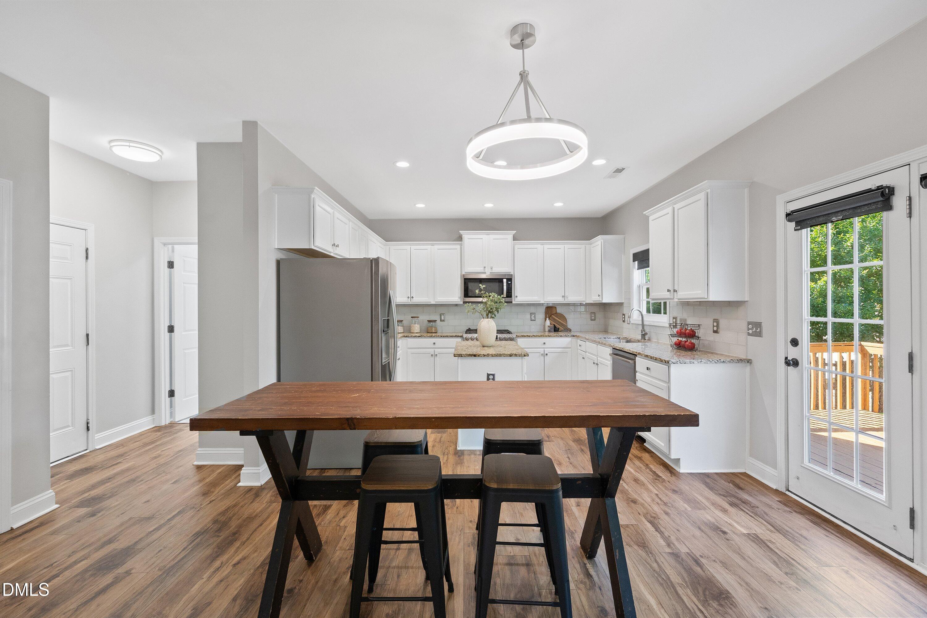3717 Windmeade Road Wake Forest, NC 27587 - Photo 17 of 51 a kitchen with a dining table chairs and refrigerator