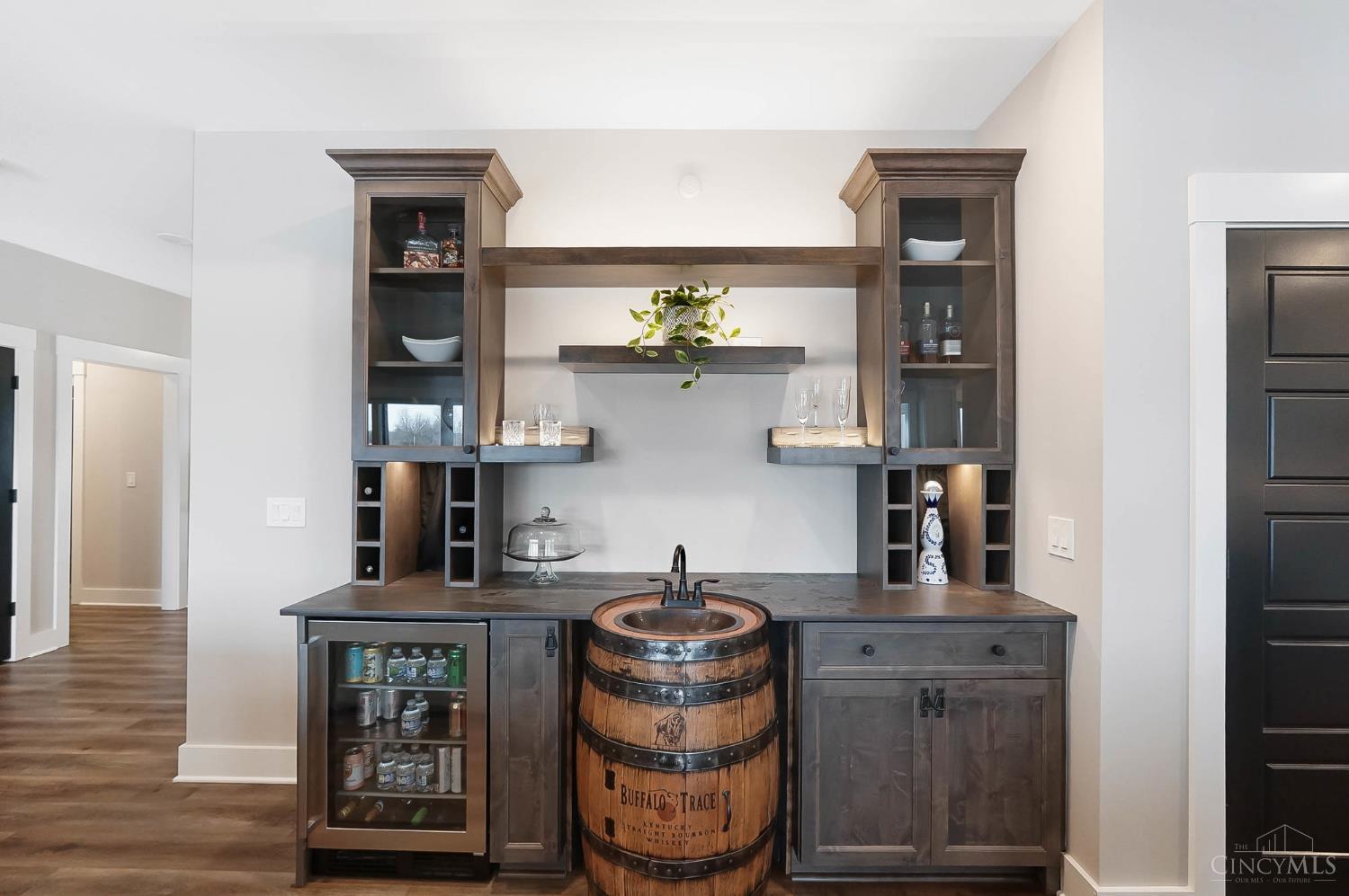 2220 Wilmington Road Lebanon, OH 45036 - Photo 23 of 91 A custom bourbon barrel centerpiece creates a bold focal point in the bar area, enhanced by a distressed metal countertop and soft accent lighting.