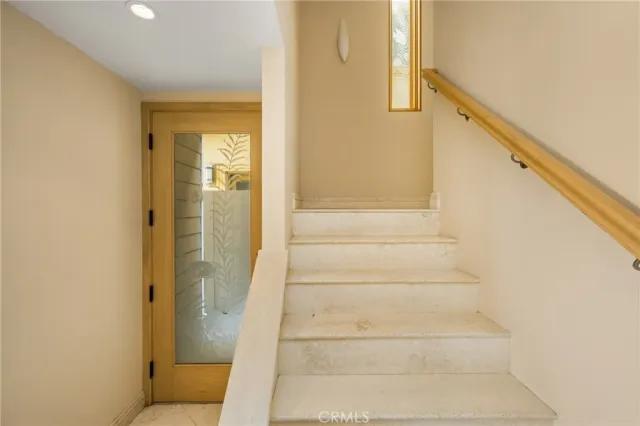 a view of staircase with white walls and white door