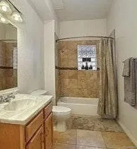 a bathroom with a granite countertop sink a toilet and shower
