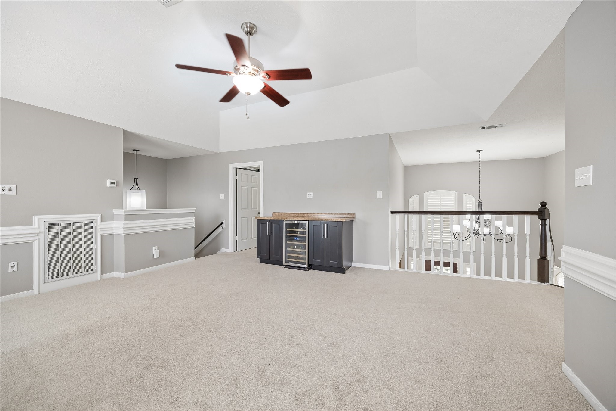 7915 Huddersfield Court Spring, TX 77379 - Photo 26 of 37 Alternate view of the upstairs game room highlighting the vaulted ceiling, built-in serving area with wine fridge, and generous space for media or entertaining.