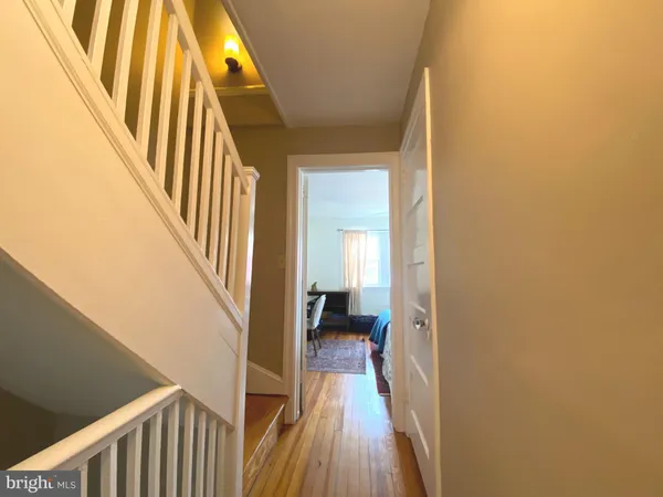 a view of a hallway with wooden floor and staircase