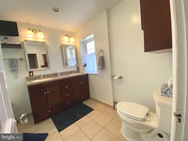 a bathroom with a toilet a sink a mirror and a shower