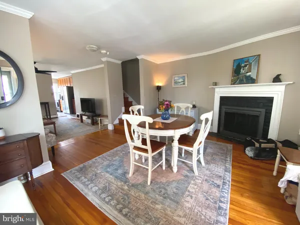 a dining room with furniture a fireplace and wooden floor