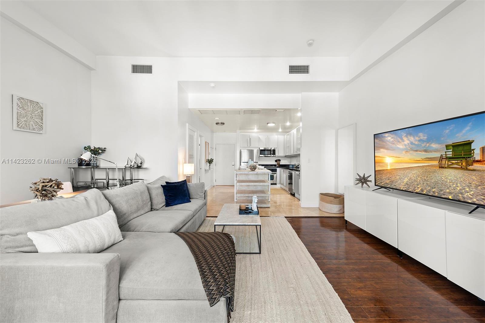 Mid Beach Miami Beach, FL 33139 - Photo 17 of 30 a living room with furniture and a flat screen tv