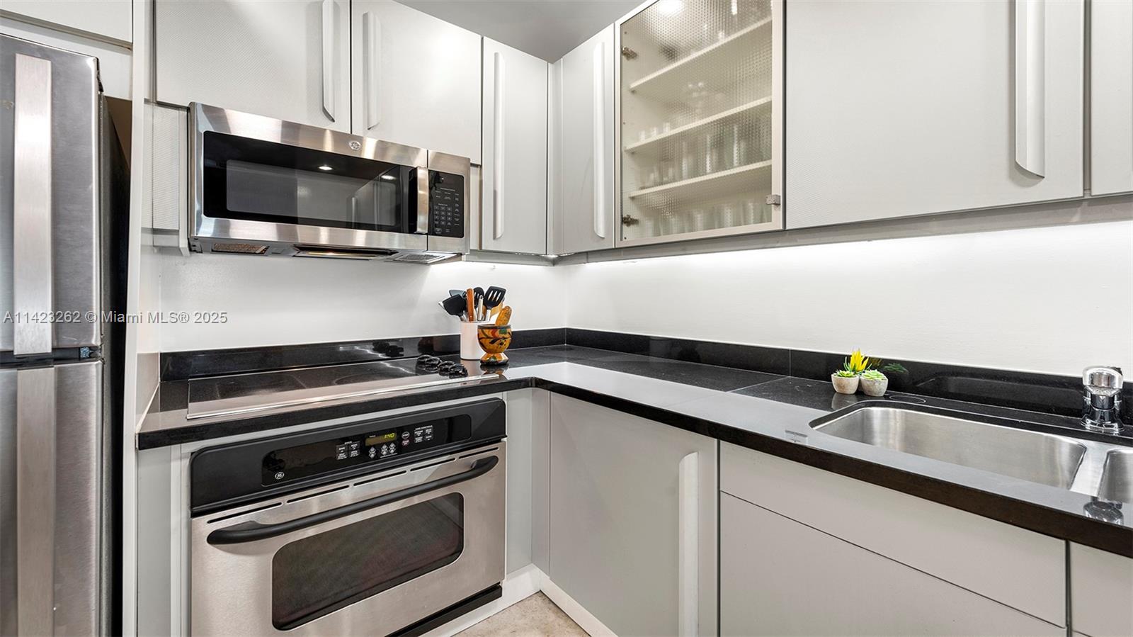 Mid Beach Miami Beach, FL 33139 - Photo 20 of 30 a kitchen with stainless steel appliances a sink a stove and microwave
