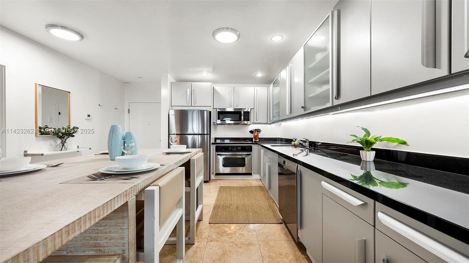 Mid Beach Miami Beach, FL 33139 - Photo 22 of 30 a kitchen with stainless steel appliances a sink stove and cabinets