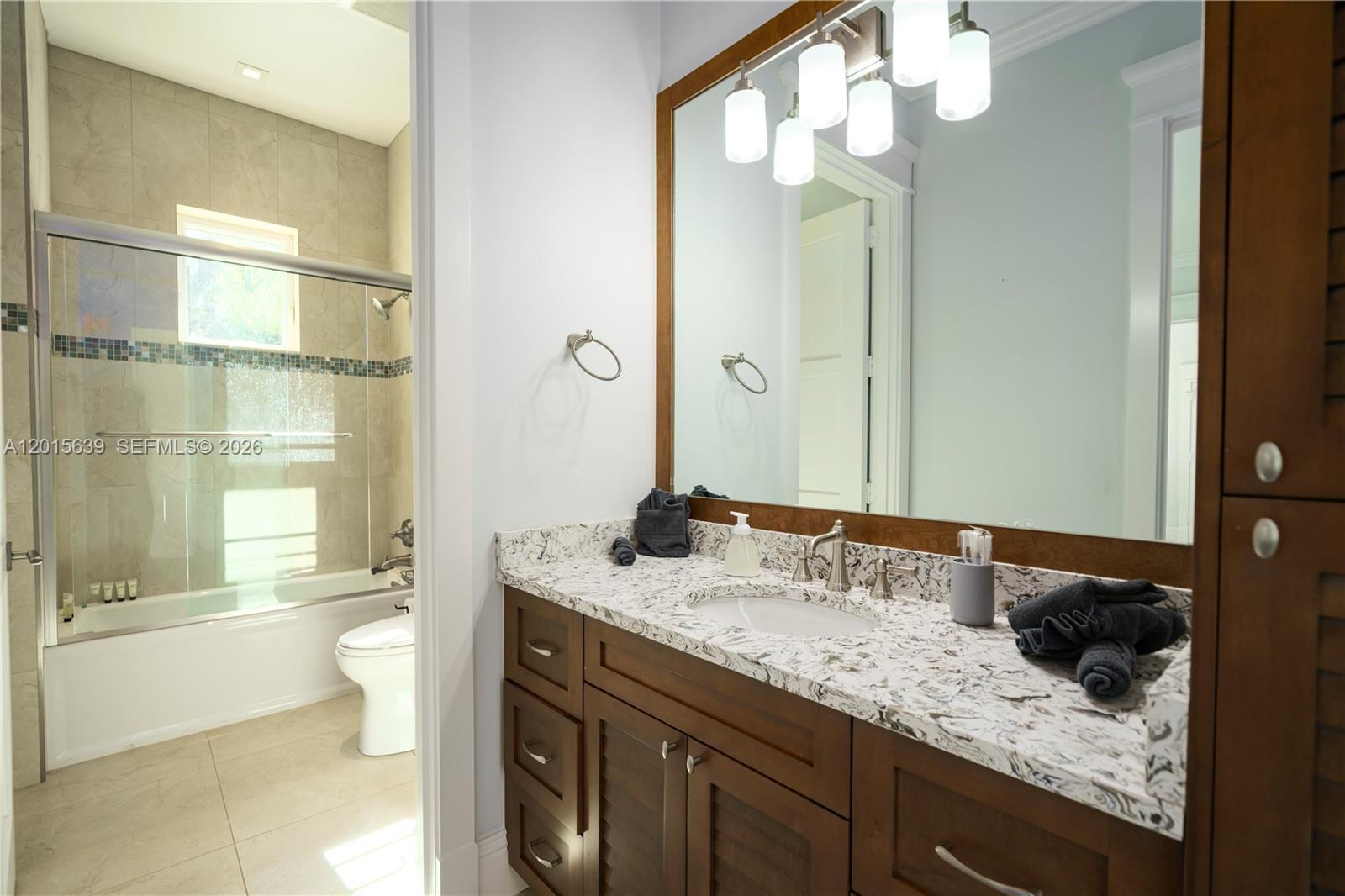 545 Southwest Indianola Street Stuart, FL 34994 - Photo 16 of 64 a bathroom with a granite countertop sink a toilet and shower