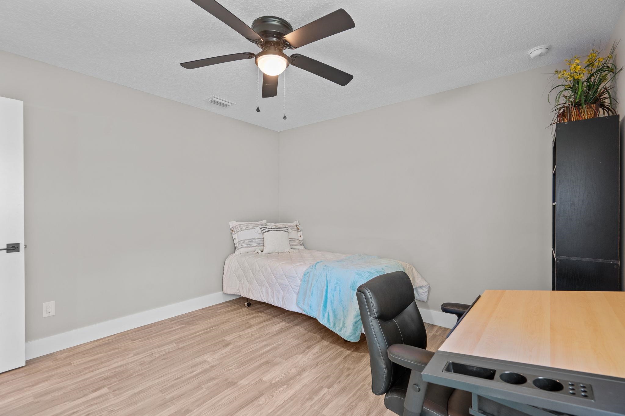 804 West 9th Street St. Augustine, FL 32084 - Photo 18 of 31 Bedroom featuring wood finished floors, a ceiling fan, a textured ceiling, and an office area