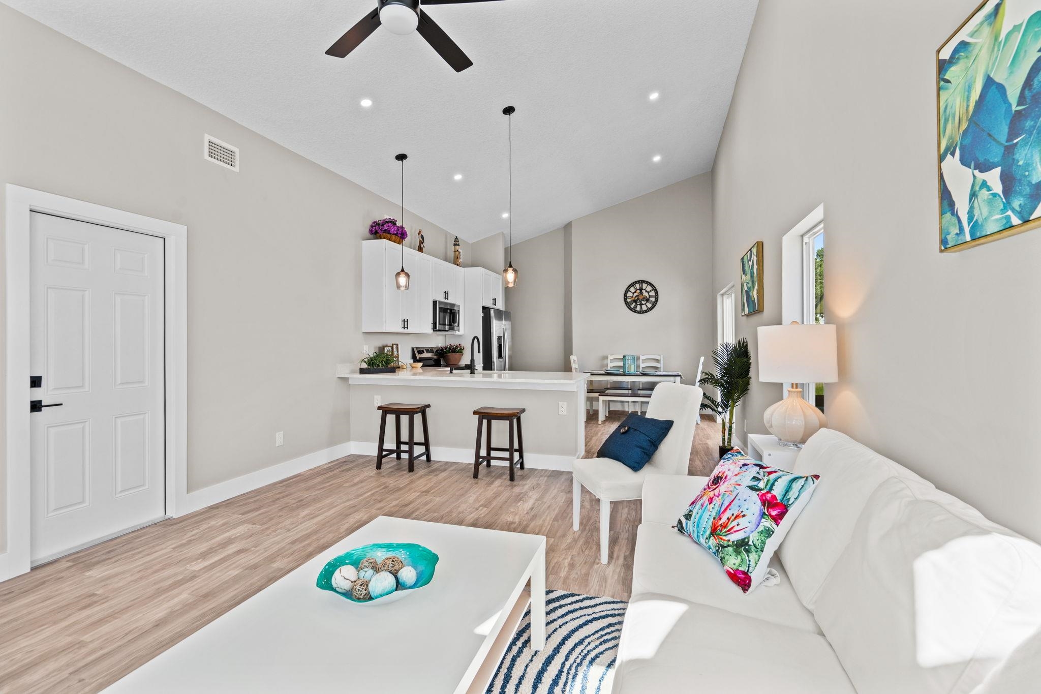 804 West 9th Street St. Augustine, FL 32084 - Photo 4 of 31 Living area with light wood-style floors, high vaulted ceiling, a ceiling fan, and recessed lighting