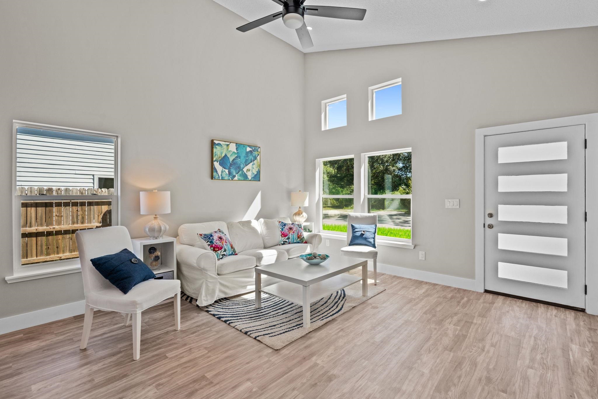 804 West 9th Street St. Augustine, FL 32084 - Photo 7 of 31 Living room with light wood finished floors, ceiling fan, and high vaulted ceiling