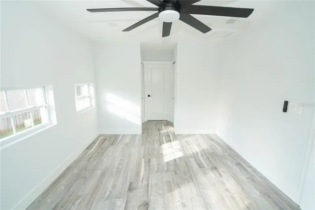 a view of empty room with wooden floor