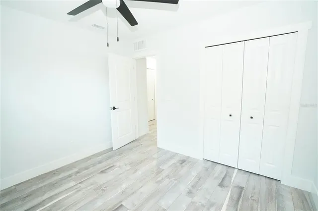an empty room with a window and a fan