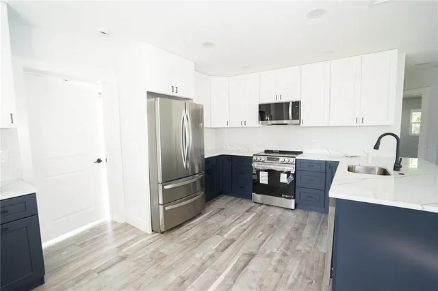 a kitchen with granite countertop a refrigerator and a stove top oven