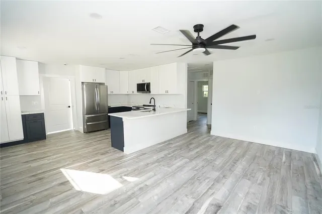 a view of a kitchen with a sink stainless steel appliances and cabinets