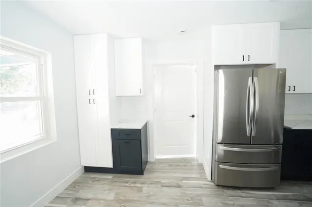 a view of kitchen with refrigerator and cabinet