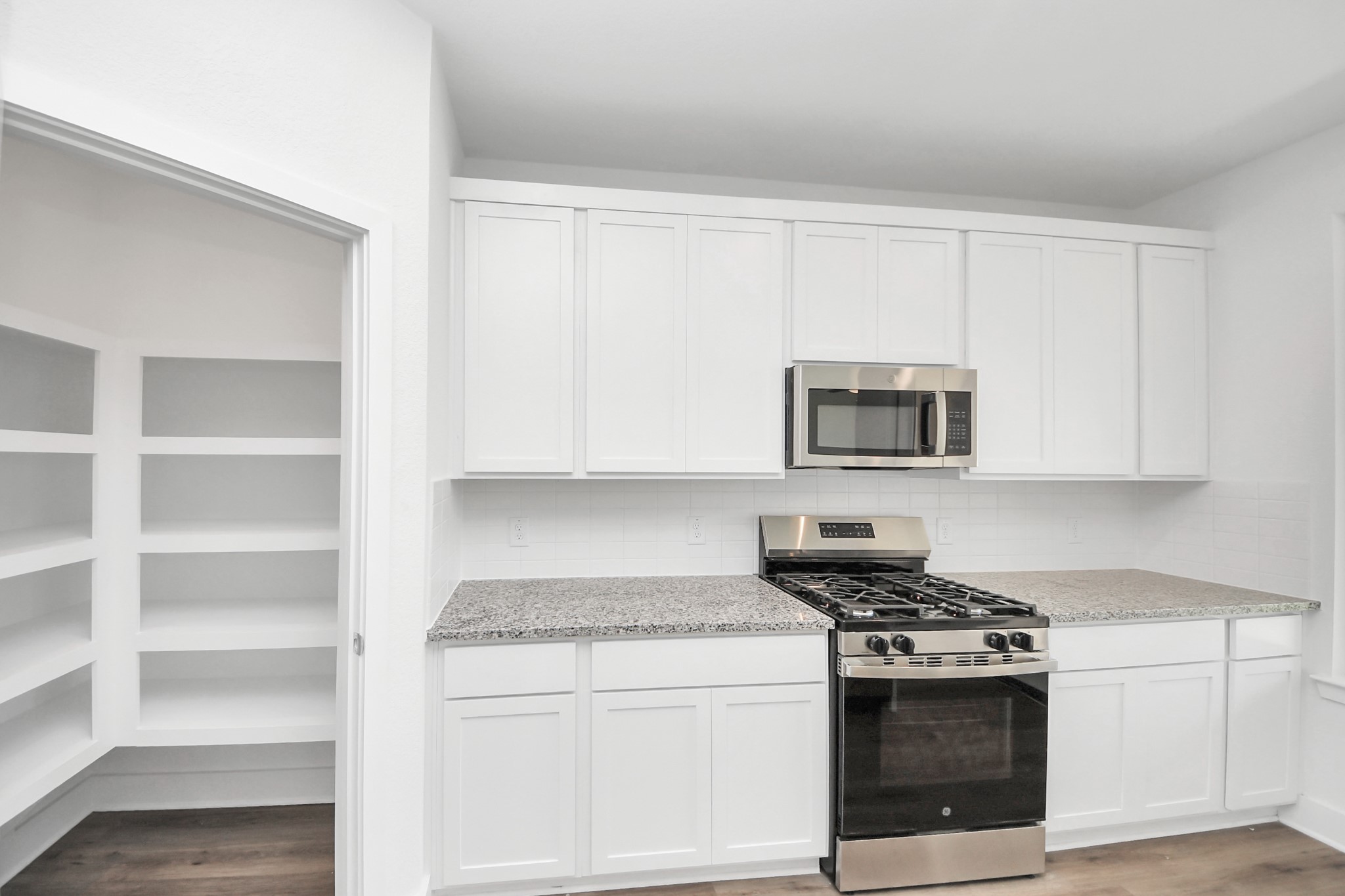 14439 Trumpet Lane Splendora, TX 77372 - Photo 11 of 37 a kitchen with stainless steel appliances granite countertop white cabinets and a stove