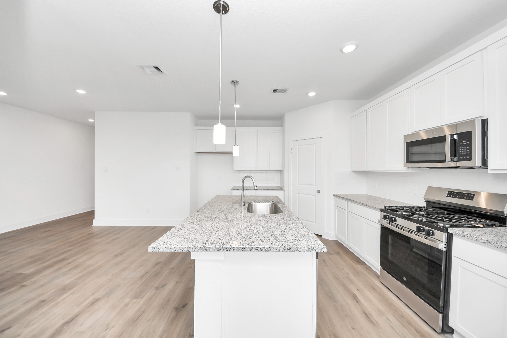 14439 Trumpet Lane Splendora, TX 77372 - Photo 12 of 37 a kitchen with granite countertop kitchen island wooden floor center island stainless steel appliances and cabinets