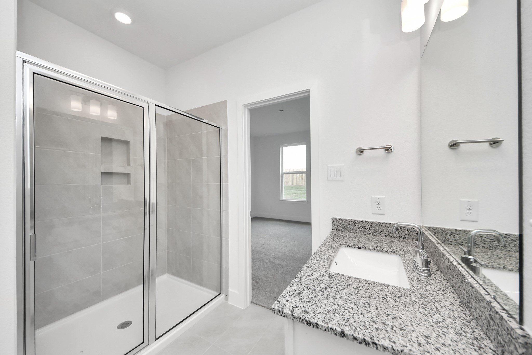 14439 Trumpet Lane Splendora, TX 77372 - Photo 16 of 37 a bathroom with a granite countertop sink a mirror and a shower