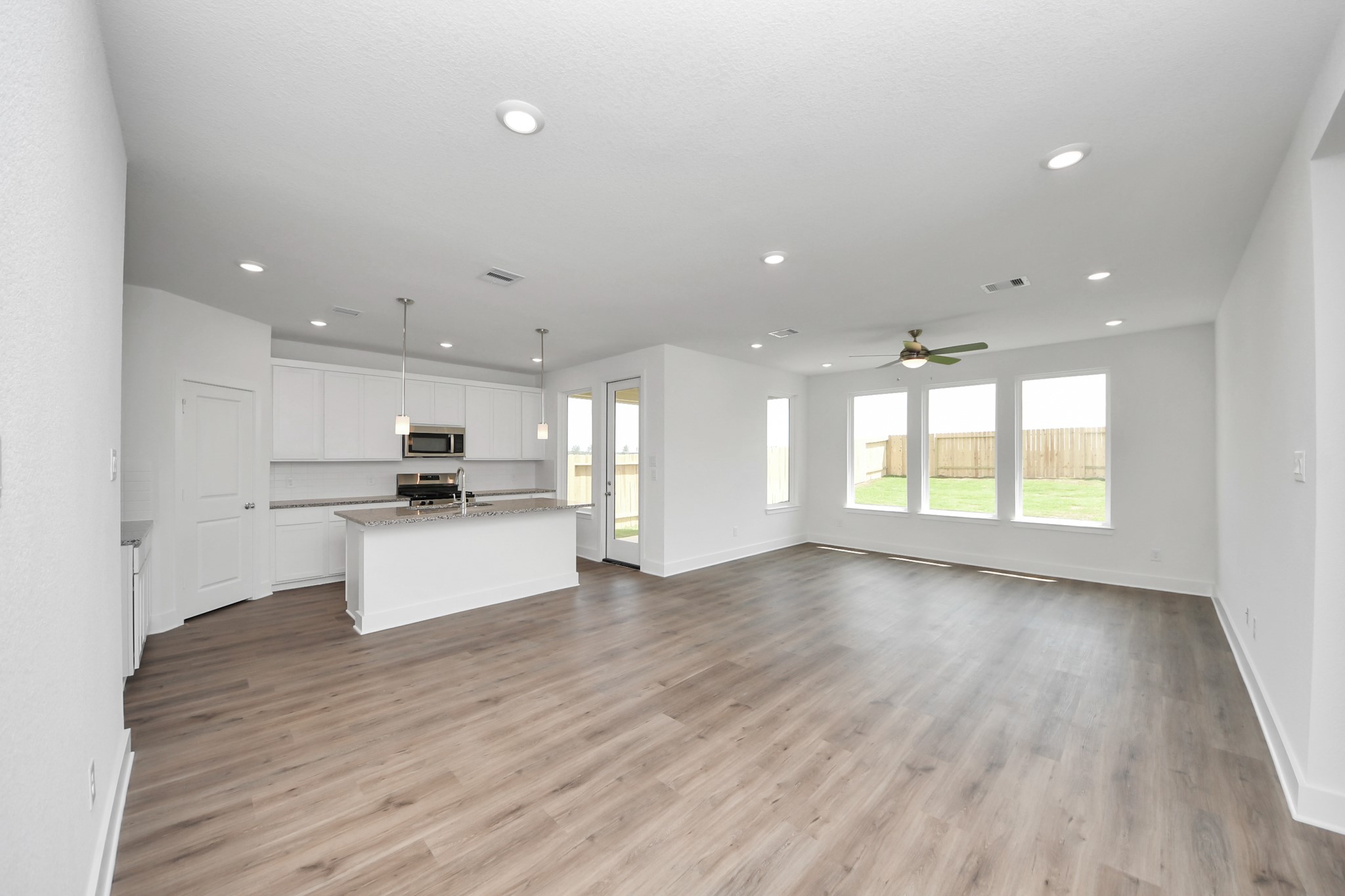 14439 Trumpet Lane Splendora, TX 77372 - Photo 5 of 37 a view of kitchen with kitchen island a sink wooden floor and a large window