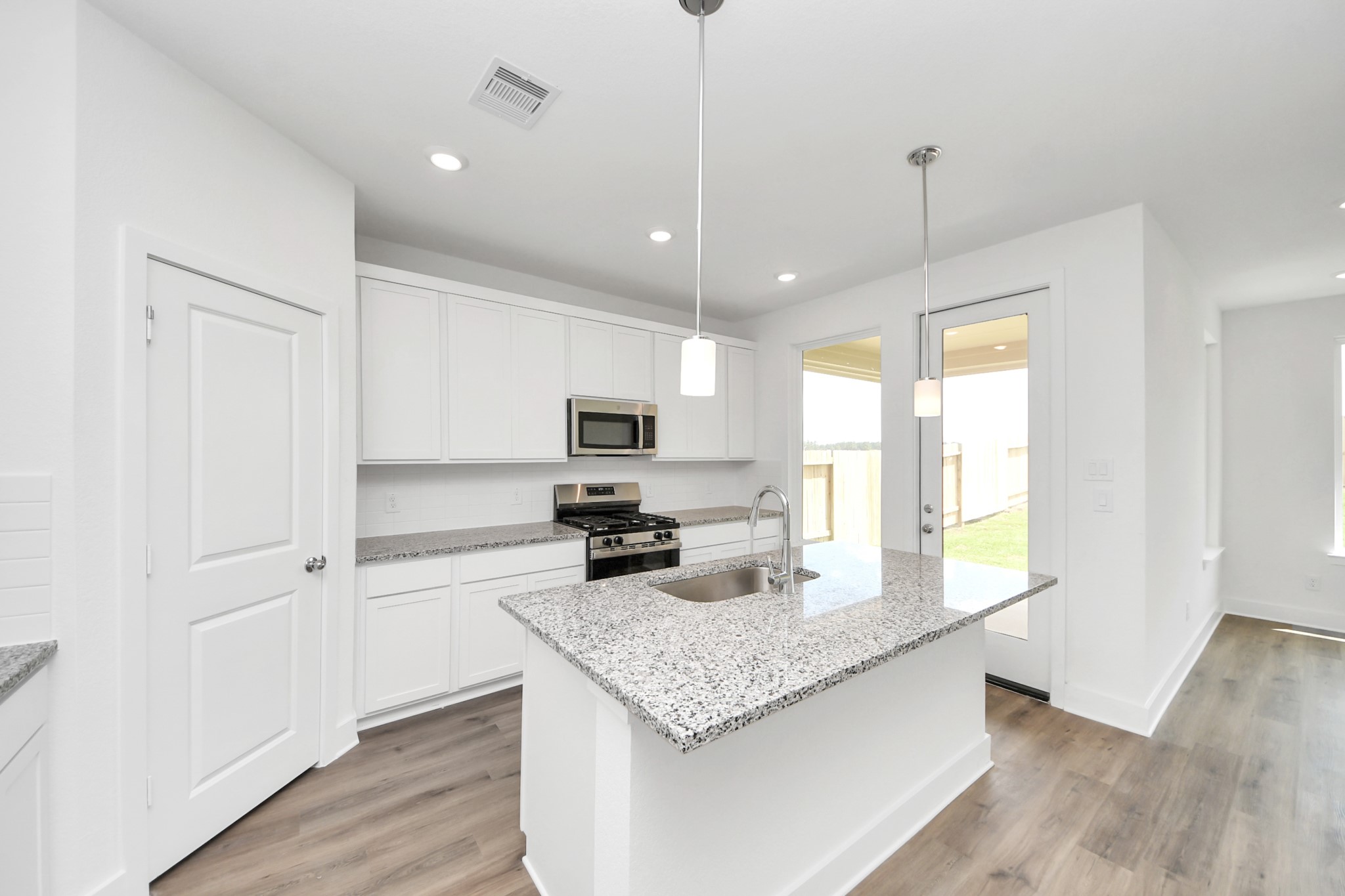 14439 Trumpet Lane Splendora, TX 77372 - Photo 8 of 37 a kitchen with granite countertop kitchen island stainless steel appliances a stove a sink a center island a refrigerator and a hard wood floor