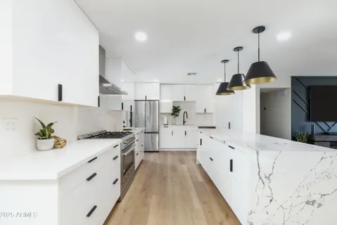 a kitchen with white cabinets sink and stainless steel appliances