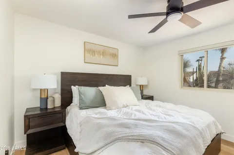 a bedroom with a bed and painting on the wall