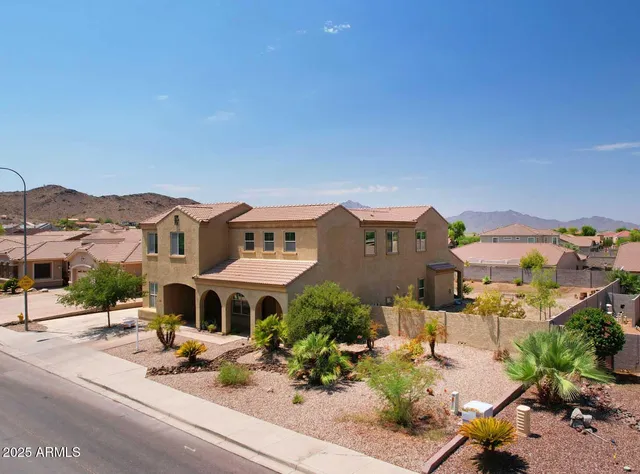 an aerial view of a house with a mountain