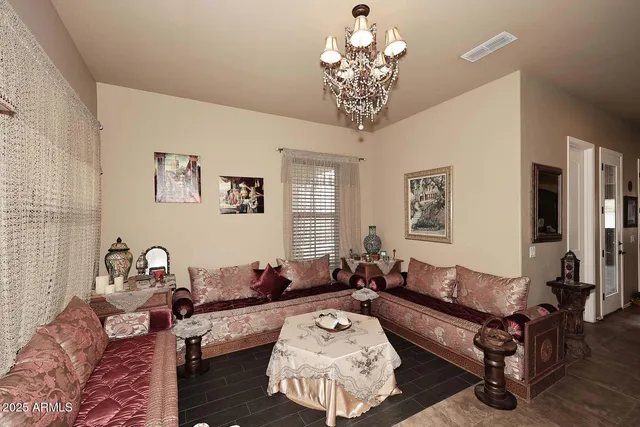 a living room with furniture a chandelier and a window