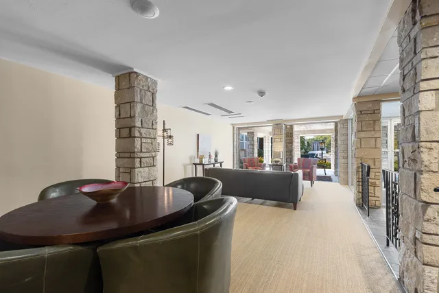 a dining room with furniture and a floor to ceiling window