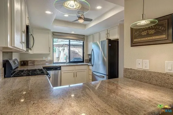 a view of a swimming pool with a patio and a yard