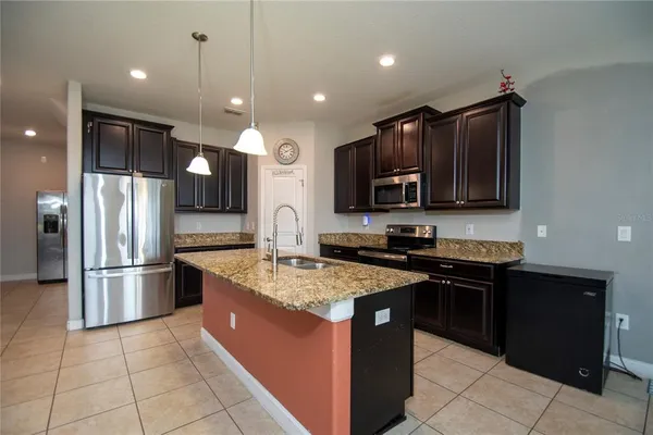 a kitchen with stainless steel appliances granite countertop a stove a refrigerator and a sink