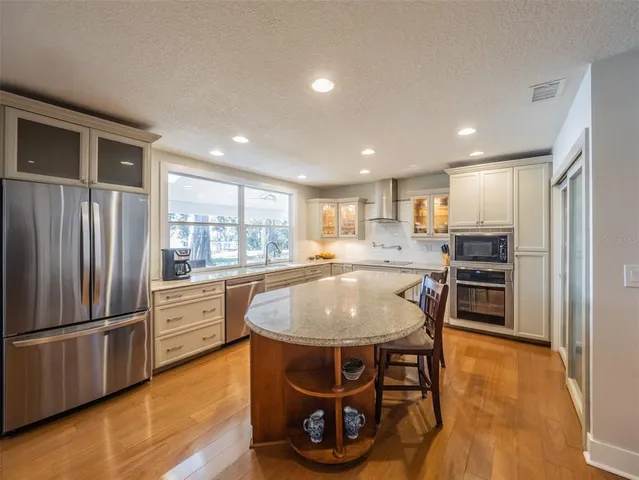 a large kitchen with granite countertop lots of counter space and windows